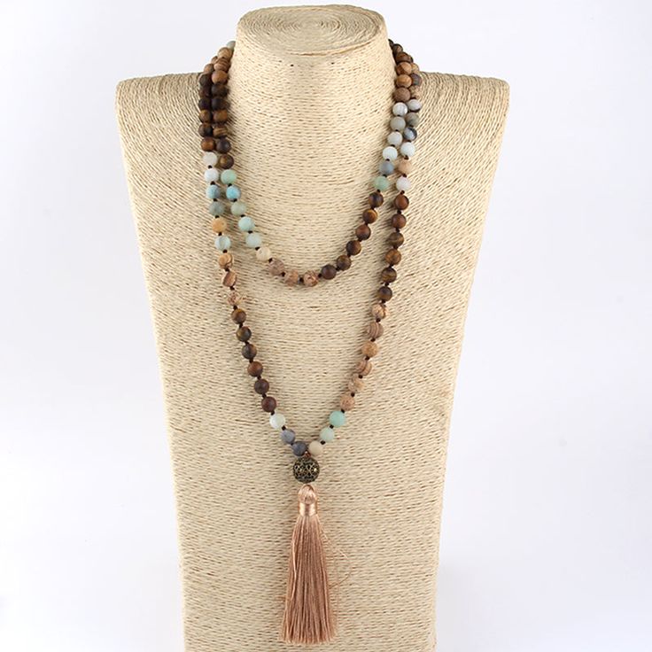 Bohemian Tribal Stone Beaded Necklace with Tassel Pendant Stylish Design Discover the beauty of nature and fashion with this statement necklace showcasing an intricate BOHO tribal stone design. This sophisticated, long strand necklace is the perfect addition to any chic look. Quality Materials Crafted with: Metal: Alloy Material: Semi-Precious Stone Perfect Length With a chain length of 104cm and a pendant length of 10.0cm, this necklace is designed to enhance your wardrobe effortlessly. Timeles Adjustable Bohemian Long Necklace With Tassels, Bohemian Long Necklace With Tassels, Bohemian 8mm Beads Necklace For Festival, Bohemian Brown Long Necklace With Round Beads, Bohemian Long Necklace With Gemstone Beads, Bohemian Necklace With 108 Round Beads, Bohemian Beige Jewelry For Meditation, Bohemian Brown Beaded Long Necklace, Bohemian Long Crystal Necklace For Beach