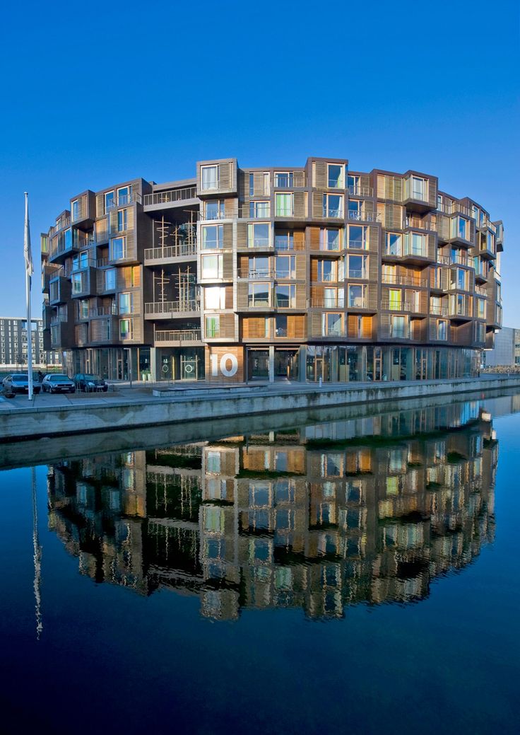 an apartment building is reflected in the water