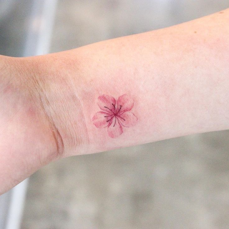 a small pink flower on the left arm