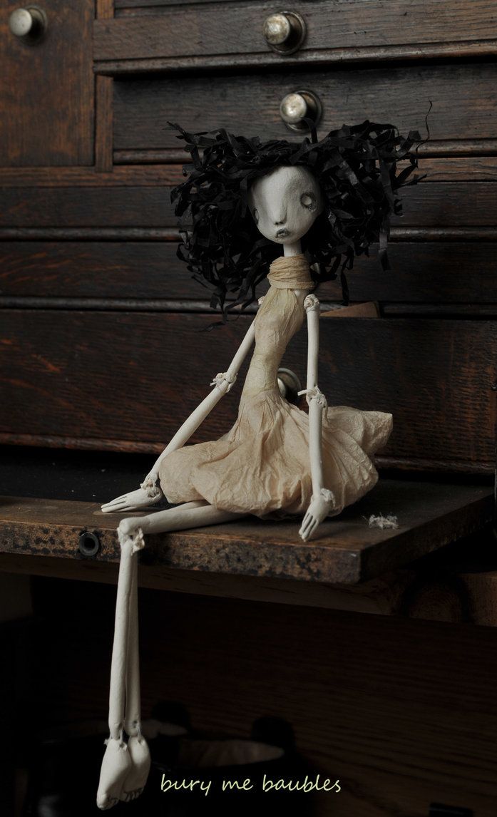 a skeleton doll sitting on top of a wooden table next to a dresser with drawers