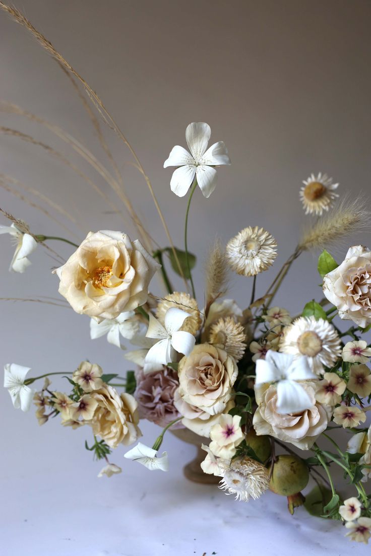 a vase filled with lots of flowers on top of a table