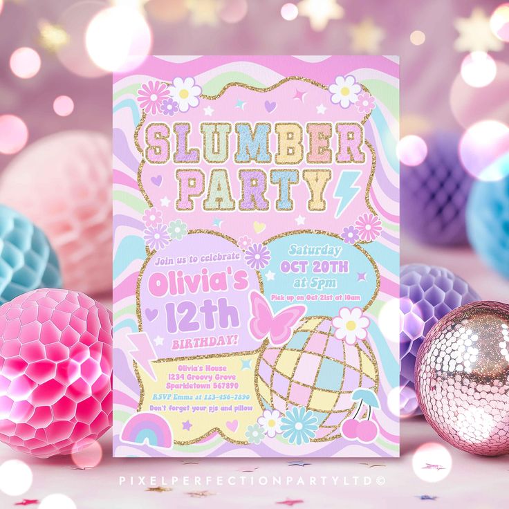 a pink and blue birthday party with paper decorations on the table next to it is a card that says, slumber party