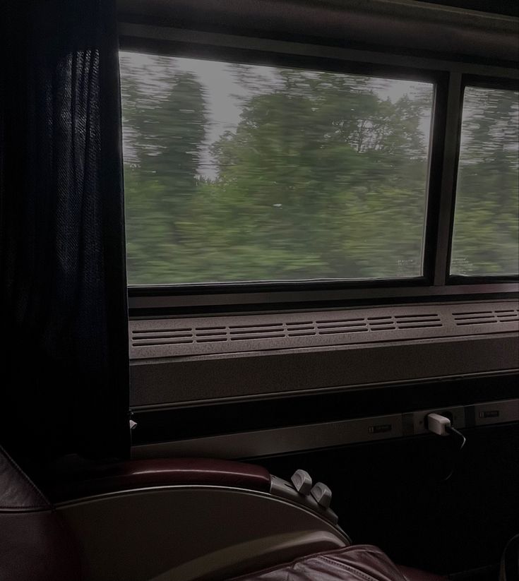 a train car with the window open and trees in the background