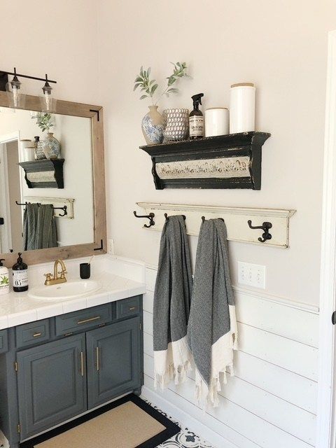 a bathroom with two towels hanging on the wall and a mirror over the sink in front of it