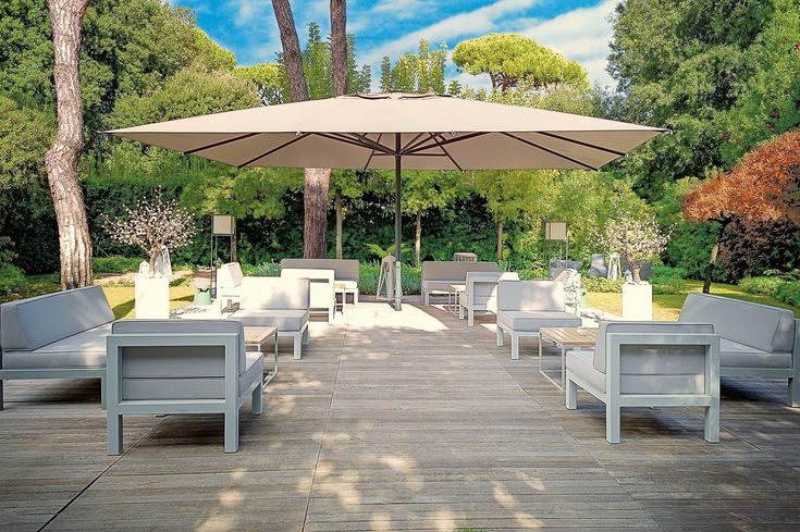 an outdoor seating area with umbrellas and tables in the shade on a sunny day