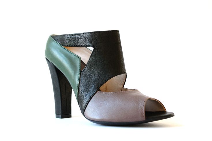 Lien is a clog style sandal, the cutout shapes and color blocking techique breakup the mostly covered design. The green accent counter pops againt the neutral leathers. Lien comes together as an edgy style which is very wearable with its clean lines, block heel and subtle color way. 100% handmade and hand-lasted. 100% Leather upper, lining and sole. Features: Leather covered heel. Heel height: 93mm. Modern Green Heels With Contrasting Heel Counter, Green Sandals With Contrasting Heel Counter, Modern Green Open Toe Mules, Green Leather Open Toe Mules, Green Open Toe Leather Mules, Green Leather Mules With Open Heel, Green Leather High Heel Mules, Green Leather Open Heel Mules, Green Leather Open-heel Mules