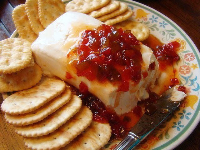 a plate with crackers, cheese and jelly on it