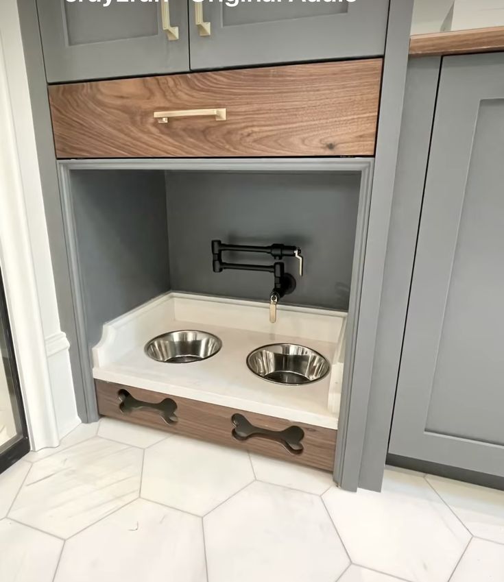 an open cabinet with two stainless steel bowls