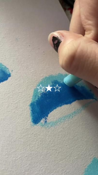 someone is drawing stars on the paper with blue and white crayon inks