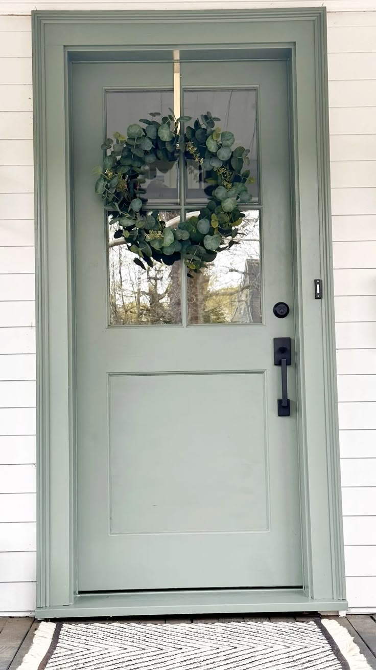 a green front door with a wreath on it