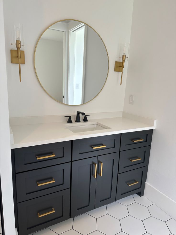 a bathroom with a sink, mirror and hexagonal floor tiles in white and black