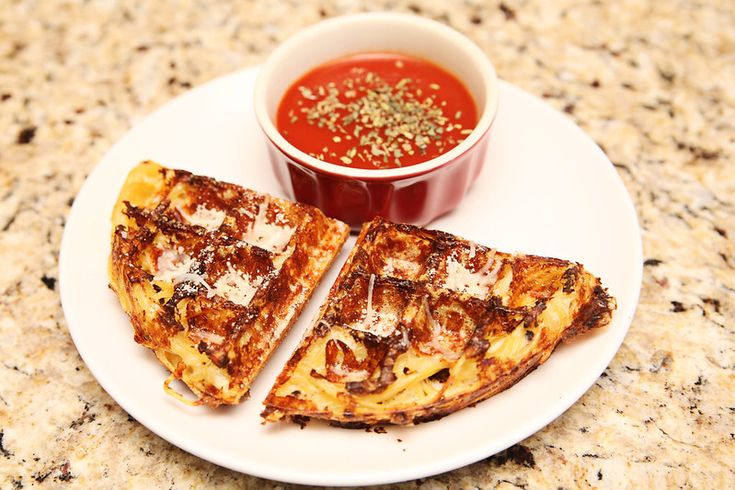 two pieces of toast on a plate with sauce in the bowl next to each other