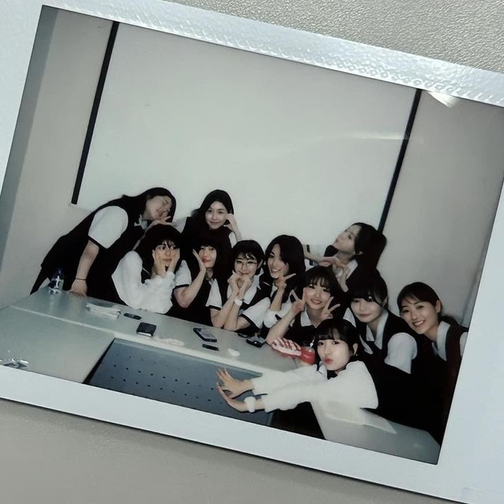 a group of young women posing for a photo in front of a white board with black writing on it