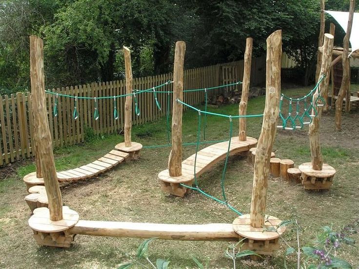 a wooden playground with ropes and logs