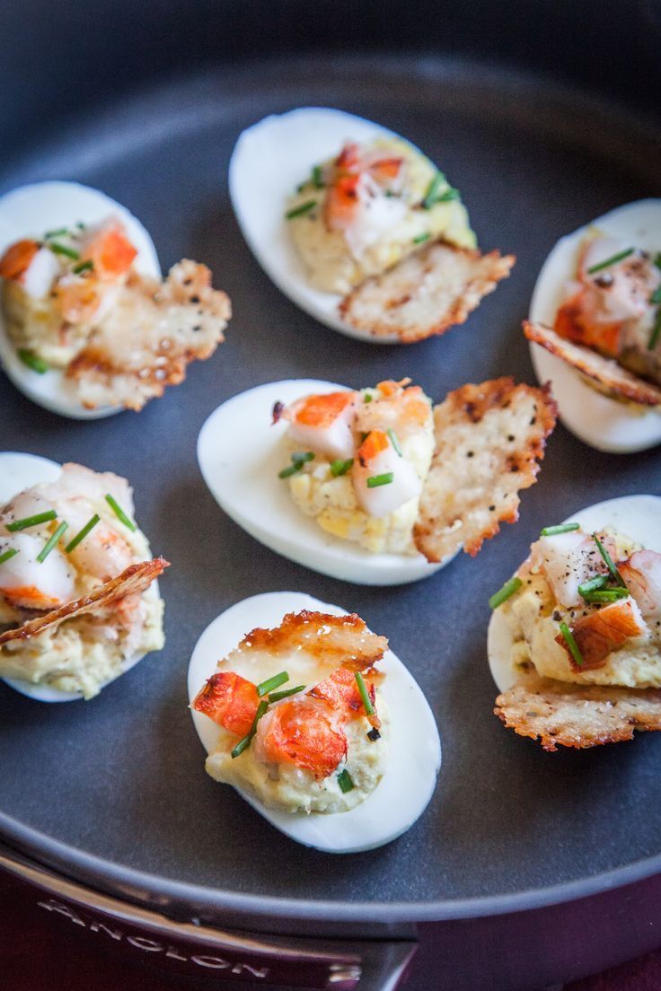 deviled eggs with shrimp and crab on them in a cast iron frying pan