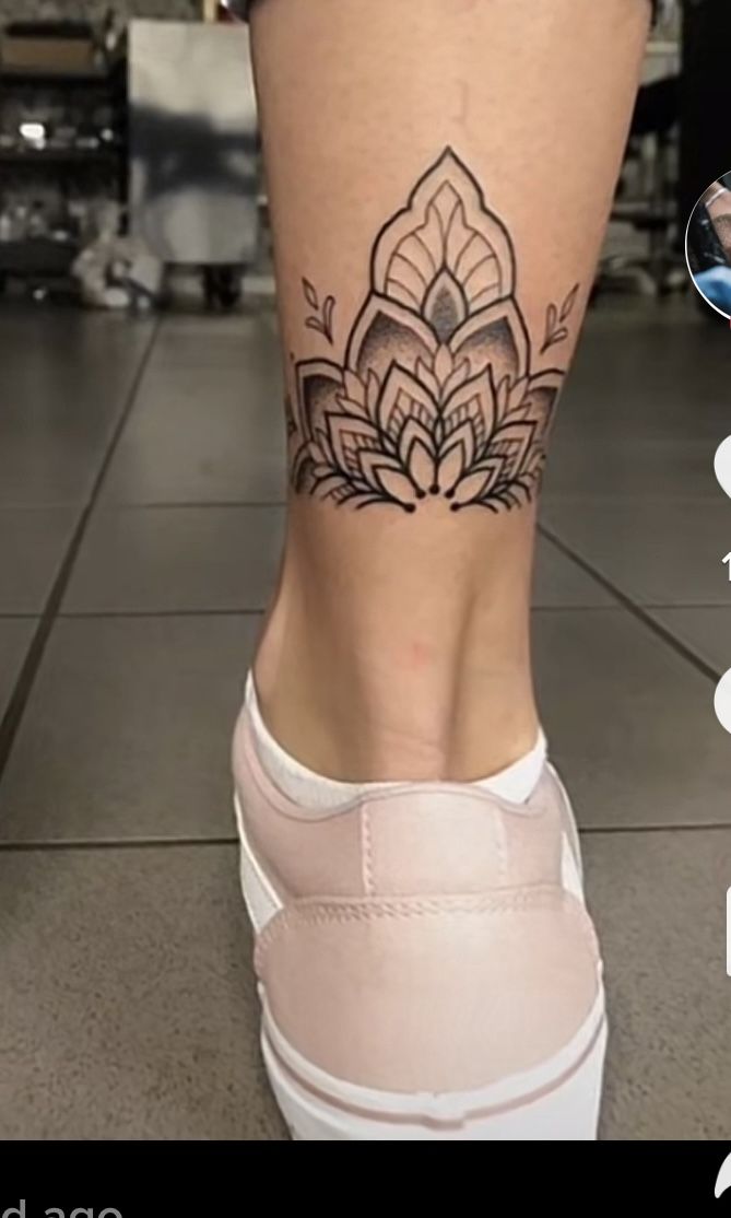 a woman's foot with a lotus tattoo on her lower leg and the bottom part of her shoe