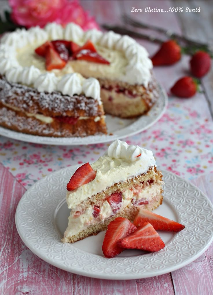 two plates with slices of cake and strawberries on them