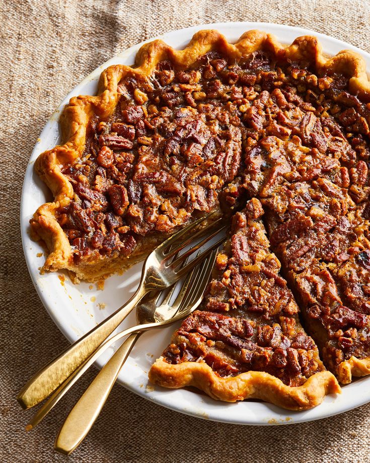 a pecan pie on a white plate with two forks