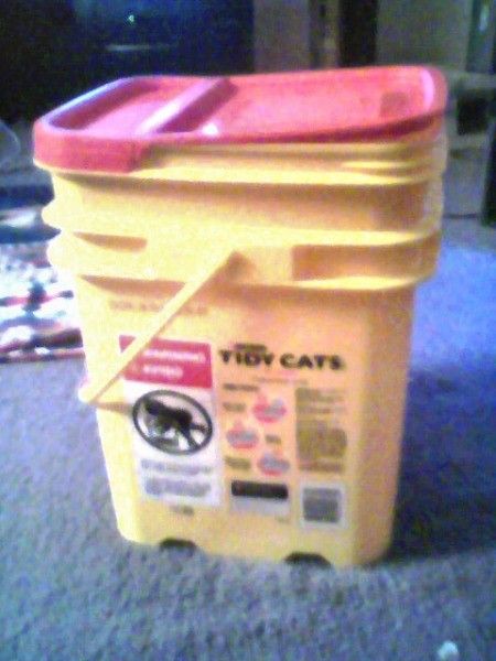 a yellow and pink container sitting on top of a carpeted floor next to a tv