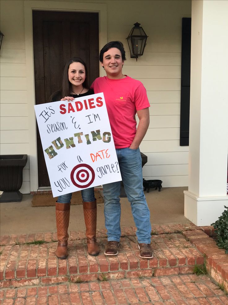 two people standing in front of a house holding a sign that says sadies i'm hunting date