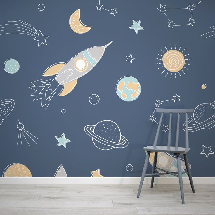 a space themed wallpaper with stars, planets and rockets painted on it in a child's room