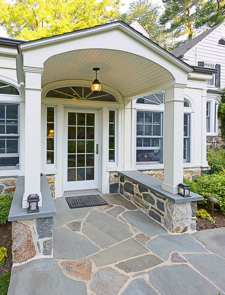 a white house with stone walkway and front door