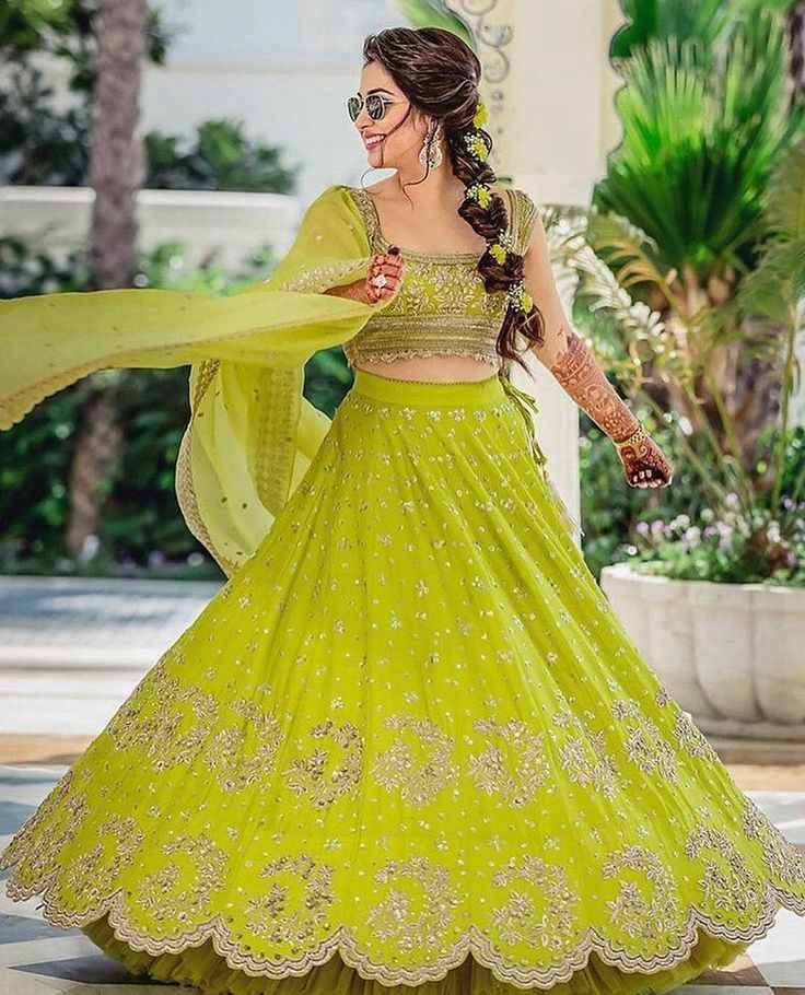 a woman in a green lehenga dancing