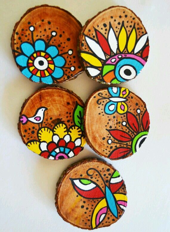 four wooden coasters with colorful designs on them