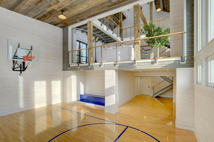 an indoor basketball court in the middle of a room with hardwood floors and white walls