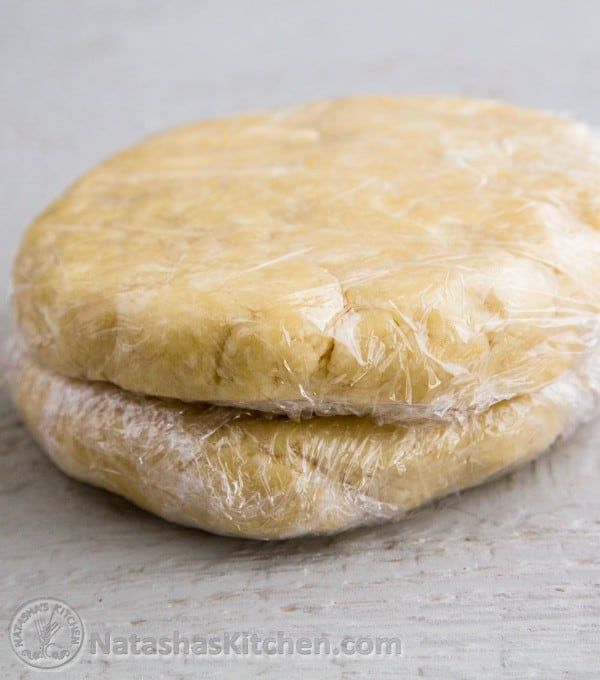 two uncooked pizza doughs sitting on top of each other