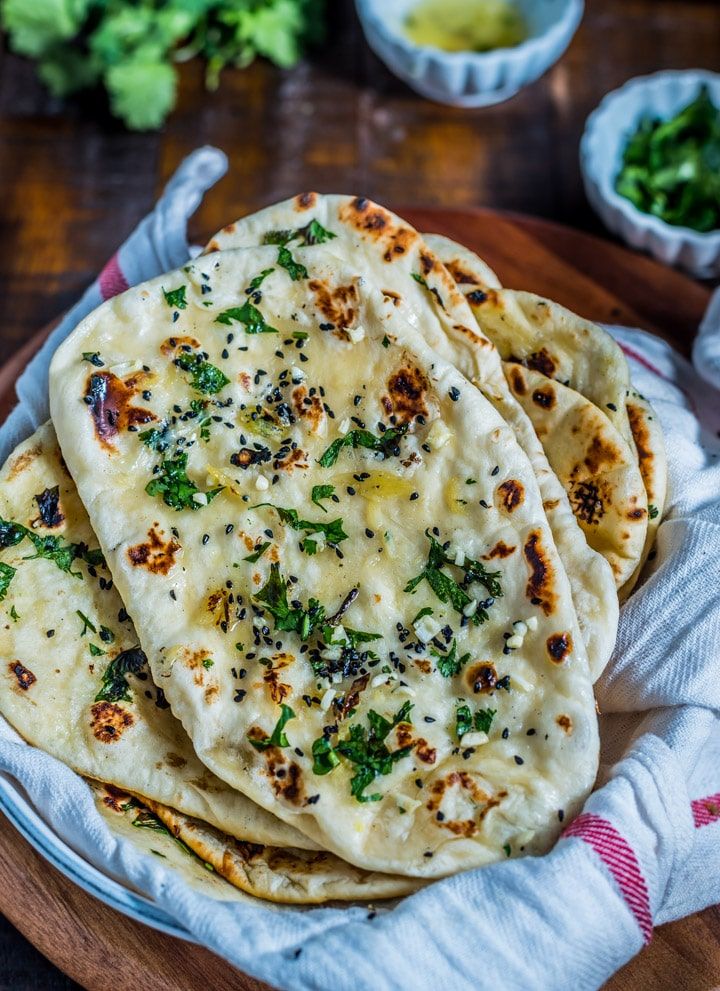 three flat breads on a plate with herbs