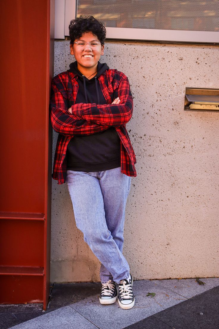 a person leaning against a wall with their arms crossed