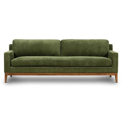 a green couch sitting on top of a wooden frame