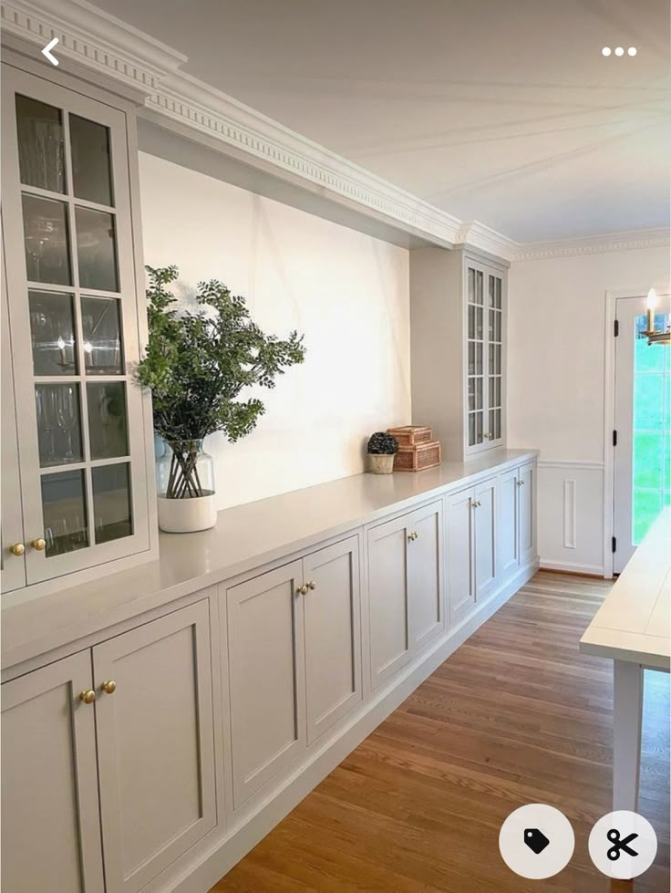 an empty kitchen with white cabinets and wood flooring is seen on the phone screen