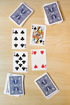 playing cards laid out on a wooden table