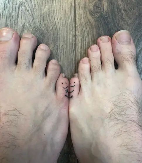 two people with their feet crossed and one has a cross tattoo on the other foot