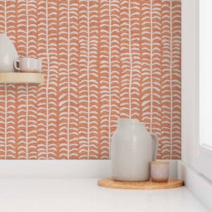 an orange and white wallpaper in a kitchen with two vases on the counter