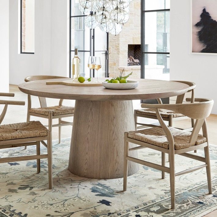 a dining room table with chairs around it and a bowl of fruit on the table