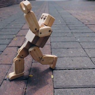 a wooden toy sitting on top of a sidewalk