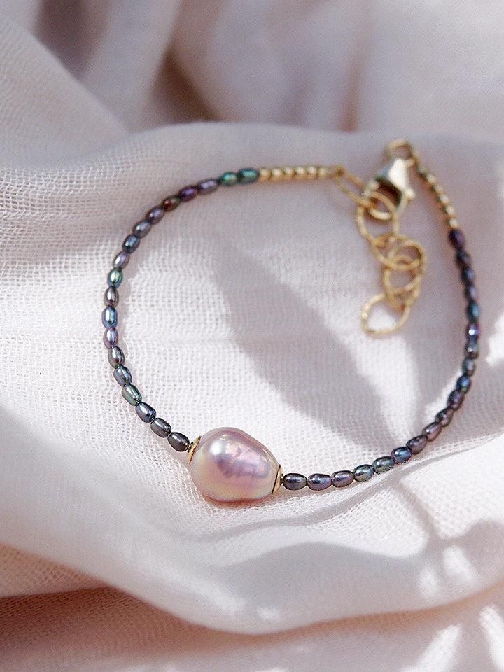 A tribute to calming seas, this beaded pearl bracelet is a handmade beauty. Accented with gold-filled details, tiny jewel toned peacock pearls and a single baroque pink pearl, this adjustable pearl bracelet is sure to become a new favorite. ✦ DETAILS ✦✧ Name: Kaimalie (KAEE ma LEE eh) - Calm sea, quiet sea.✧ Adjustable Length from: 6.5"-8".✧ 1 Pink Baroque Freshwater Pearls.✧ 2-3mm Peacock Freshwater Pearls.✧ 14kt Gold Filled Components, Extender, and Clasp.✧ All Ke Aloha Jewelry pieces come pac Adjustable Baroque Pearl Beaded Bracelets With Pearl Drop, Adjustable Baroque Pearl Beaded Bracelets, Adjustable Baroque Pearl Bracelet With Pearl Drop, Adjustable Dainty Baroque Pearl Bracelet, Dainty Adjustable Baroque Pearl Bracelet, Handmade Adjustable Baroque Pearl Beaded Bracelets, Handmade Gold Beaded Bracelets With Baroque Pearls, Gift Baroque Pearl Beaded Bracelet With Pearl Charm, Gift Baroque Pearl Beaded Bracelet