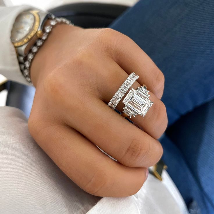 a woman's hand with a diamond ring on her left and a watch on her right