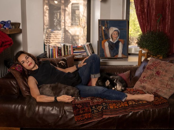 a woman sitting on a couch with her cat