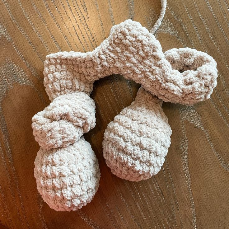 two crocheted dog toys sitting on top of a wooden table