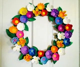 a paper flower wreath hanging on the front door