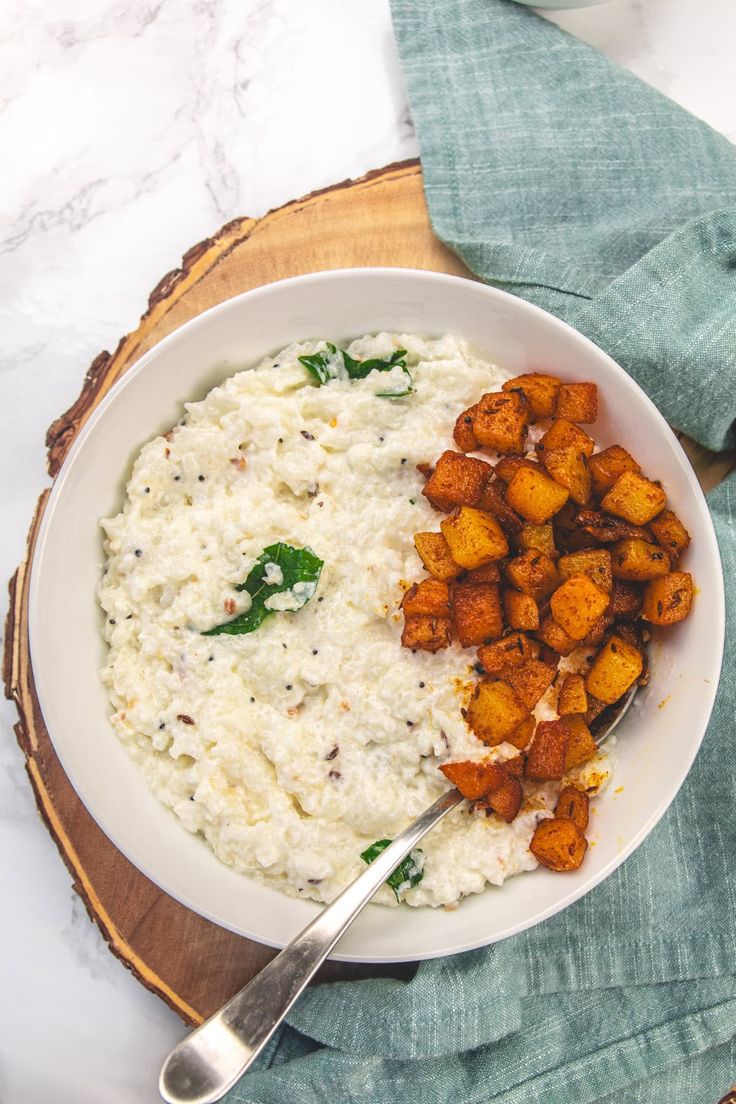 a white bowl filled with rice and potatoes