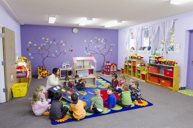 children are sitting on the floor playing with blocks and toys in a child's playroom