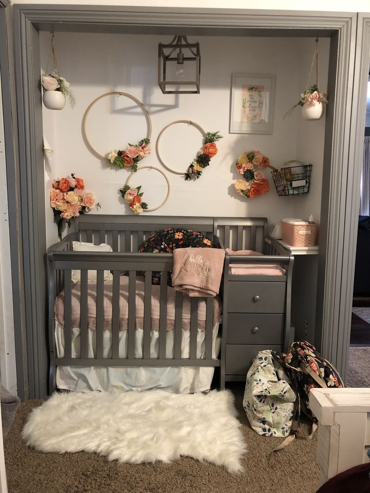 a baby crib with flowers and wreaths on the wall