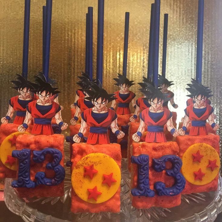 dragon ball themed birthday cake with candles and figurines on display in front of them