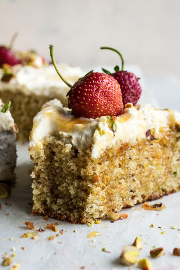 a piece of cake with white frosting and strawberries on top