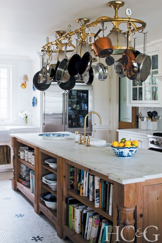 a kitchen with an island and hanging pot rack